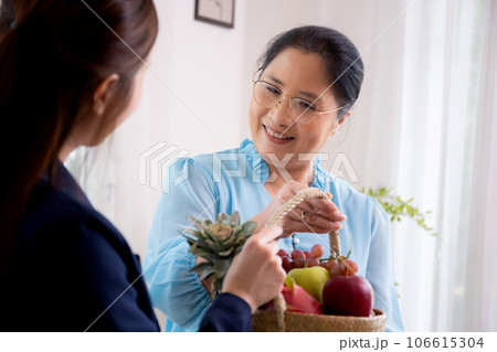 Young asian woman agent insurance visit customer elderly while giving fruit basket. Young asian woman agent insurance visit customer elderly while giving fruit basket. 106615304