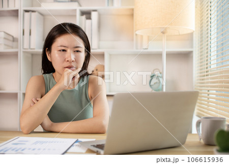 Woman using laptop to work or do homework at home with smiling face in her office, Creating happiness at work with a smile, Live performance or vdo call with laptop, Work from home. 106615936