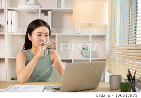 Woman using laptop to work or do homework at home with smiling face in her office, Creating happiness at work with a smile, Live performance or vdo call with laptop, Work from home. Woman using laptop to work or do homework at home with smiling face in her office, Creating happiness at work with a smile, Live performance or vdo call with laptop, Work from home. 106615975