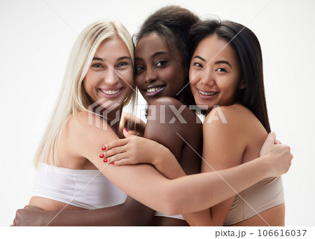 Beautiful young women of different race, asian, caucasian and african, looking at camera with smile against white background 106616037
