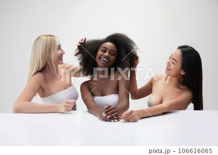 Portrait of cheerful, beautiful, three young multiracial woman smiling against white background Portrait of cheerful, beautiful, three young multiracial woman smiling against white background 106616065