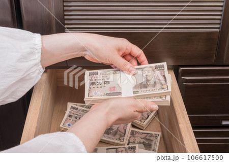 【たんすの引き出しに札束を隠す主婦】 106617500