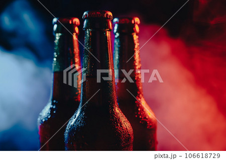Three bottles of beer in a blue-pink mist. Three bottles of beer in a blue-pink mist. 106618729
