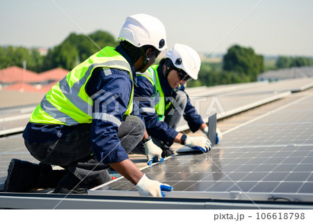 Engineers with safety helmet checking solar system at solar power farm 106618798