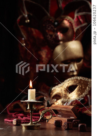 Burning candle, dice, and carnival masks. 106620237