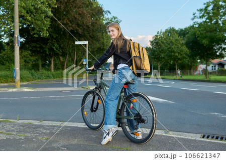 Portrait of teenage student girl with backpack on bicycle 106621347