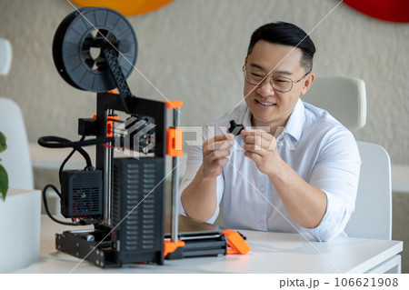 Male designer using 3D printer in office, working with new technology ideas. Male designer using 3D printer in office, working with new technology ideas. 106621908