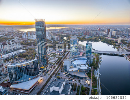Yekaterinburg city and pond aerial panoramic view at summer or early autumn sunset. Night city in the early autumn or summer. Yekaterinburg city and pond aerial panoramic view at summer or early autumn sunset. Night city in the early autumn or summer. 106622032