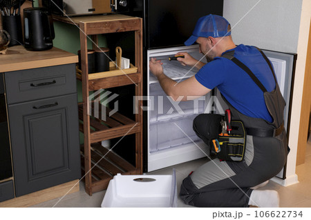 An electrical technician working on the repair of a refrigerator or refrigeration equipment An electrical technician working on the repair of a refrigerator or refrigeration equipment 106622734