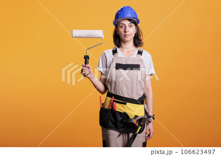 Contractor painter painting walls with roller brush tool doing interior renovation, working on home improvement. Professional construction worker holding paintbrush and roll to redecorate. Contractor painter painting walls with roller brush tool doing interior renovation, working on home improvement. Professional construction worker holding paintbrush and roll to redecorate. 106623497