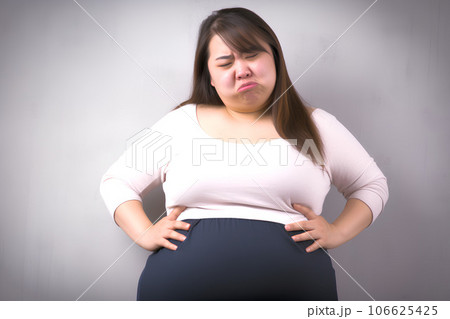 お腹のぜい肉に落ち込む女性　AI生成 106625425