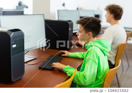 Preteen boy learning basics of programming in computer college 106625882