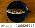 青い皿に乗った鯵の塩焼き 106626515