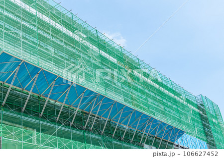 足場が組まれた高層ビルの建設現場(建築現場イメージ) 足場が組まれた高層ビルの建設現場(建築現場イメージ) 106627452