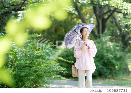 日傘を刺して歩くシニアの女性 日傘を刺して歩くシニアの女性 106627731