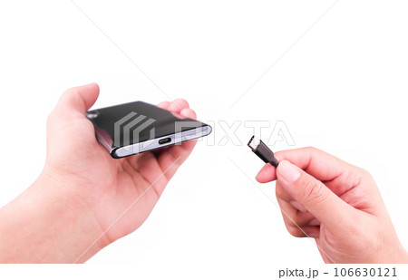 Hand inserting the charging cable into the Type C port of a smartphone. Charging your phone concept 106630121