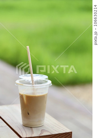 テラス席のプラスチックカップ入りの飲みかけアイスラテ 106630214