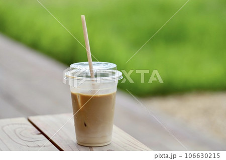 テラス席のプラスチックカップ入りの飲みかけアイスラテ 106630215