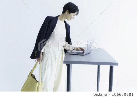 白背景のノートパソコンを操作する若い女性のファッションポートレート 106630381