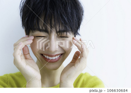 白背景の黄色い服を着た笑顔の若い女性 106630684