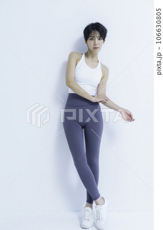 白背景のヨガウェアを着た若い女性のポートレート　縦位置 106630805