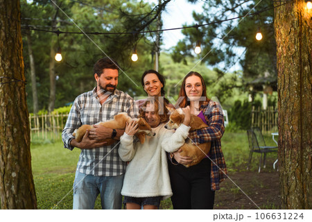 Family members father, mother and two daughters with corgi dogs in the forest Family members father, mother and two daughters with corgi dogs in the forest 106631224