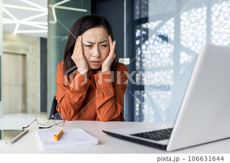 Overtired and overworked asian woman at workplace inside office, worker has severe headache and migraine, business woman holding hand on head. Overtired and overworked asian woman at workplace inside office, worker has severe headache and migraine, business woman holding hand on head. 106631644