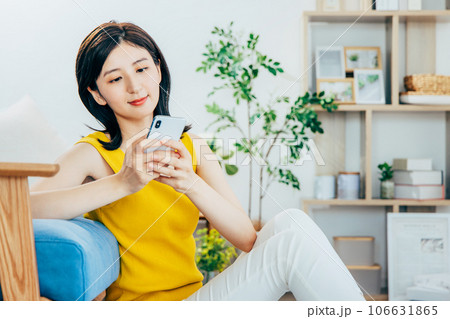 部屋でスマホを見る女性 106631865