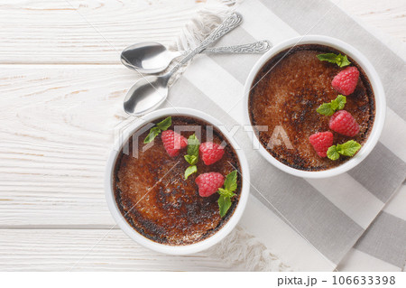 Chocolate creme brulee dessert consisting of a rich custard base topped with a layer of hardened caramelized sugar close-up in a ramekin. Horizontal top view 106633398