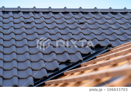 construction of the roof of a family house, wooden beams and ceramic tiles 106633703