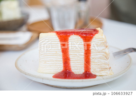Home made crepe cake on white disk with strawberry cream Home made crepe cake on white disk with strawberry cream 106633927
