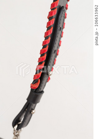 Black leather bag strap with red decoration, close-up on white background Black leather bag strap with red decoration, close-up on white background 106633962