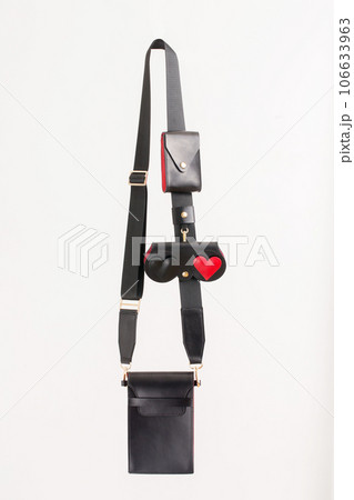 A small smartphone bag made of black leather with red inserts on the strap A small smartphone bag made of black leather with red inserts on the strap 106633963