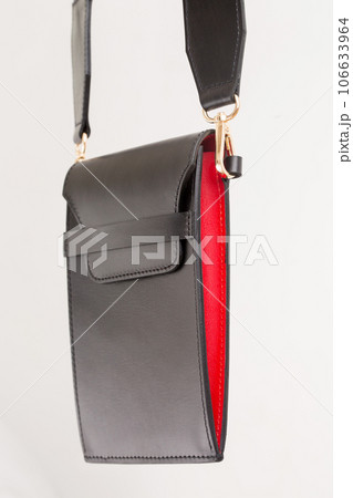A small smartphone bag made of black leather with red inserts on the strap A small smartphone bag made of black leather with red inserts on the strap 106633964