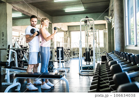 Man and woman working out with dumbbell in fitnes sport gym Man and woman working out with dumbbell in fitnes sport gym 106634038