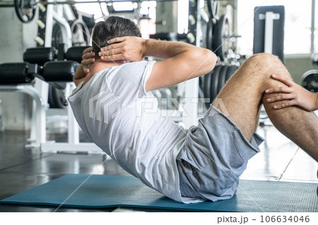 Sport man sit uplying on yoga mat exercise in gym Sport man sit uplying on yoga mat exercise in gym 106634046