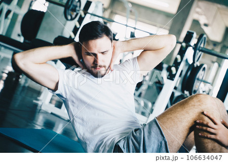 Sport man sit uplying on yoga mat exercise in gym 106634047