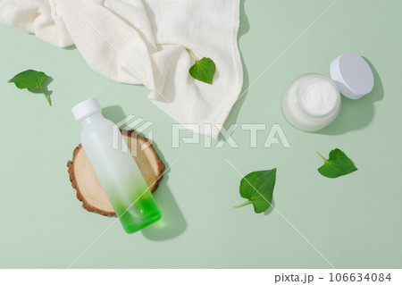 Pastel background with minimalist concept for advertising cosmetics extracted from fish mint leaf. Bottle and jar mockup unlabeled for design decorated with fresh fish mint leaves Pastel background with minimalist concept for advertising cosmetics extracted from fish mint leaf. Bottle and jar mockup unlabeled for design decorated with fresh fish mint leaves 106634084