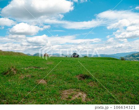 Village in Zakarpattya region with old authentic wooden houses Carpathian mountains view Ukraine Europe. Cottagecore Village in Zakarpattya region with old authentic wooden houses Carpathian mountains view Ukraine Europe. Cottagecore 106634321