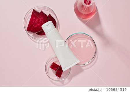 Mockup scene for advertising cosmetic extracted from beetroot. A white plastic tube unlabeled on petri dishes containing slices and essence of beetroot on pink background. Top view, space for design Mockup scene for advertising cosmetic extracted from beetroot. A white plastic tube unlabeled on petri dishes containing slices and essence of beetroot on pink background. Top view, space for design 106634515