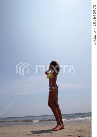 夏イメージ、砂浜に立つビキニの女性 106640478