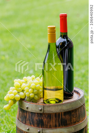 Wine bottles and grape on barrel 106640992
