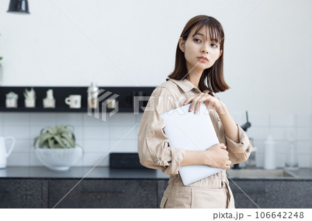 キッチンに立つ作業着の女性 106642248