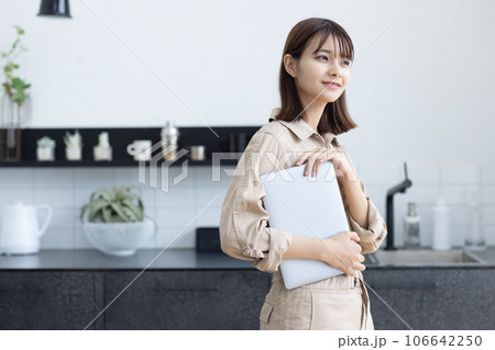 キッチンに立つ作業着の女性 キッチンに立つ作業着の女性 106642250