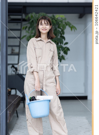 清掃道具を持つ作業着の女性 清掃道具を持つ作業着の女性 106642421