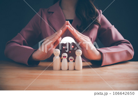 Woman's hands with protective gesture a wooden doll inside. International day of families. Hands protecting family. insurance, domestic violence, world mental health day, Family care concept. 106642650