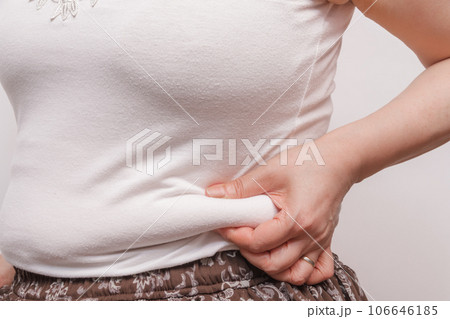 【お腹の肉を摘む主婦】 106646185
