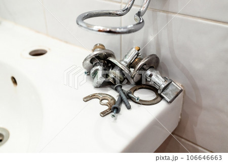 old ball valves and fixtures lie on edge of sink 106646663