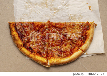 Piece of pizza in cardboard pizza box. Pizza box with leftowers. Top view 106647974
