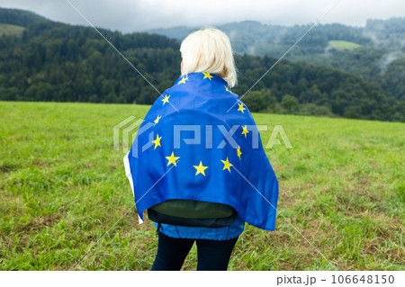 Woman with waving european union flag on a mountain background. Woman with waving european union flag on a mountain background. 106648150